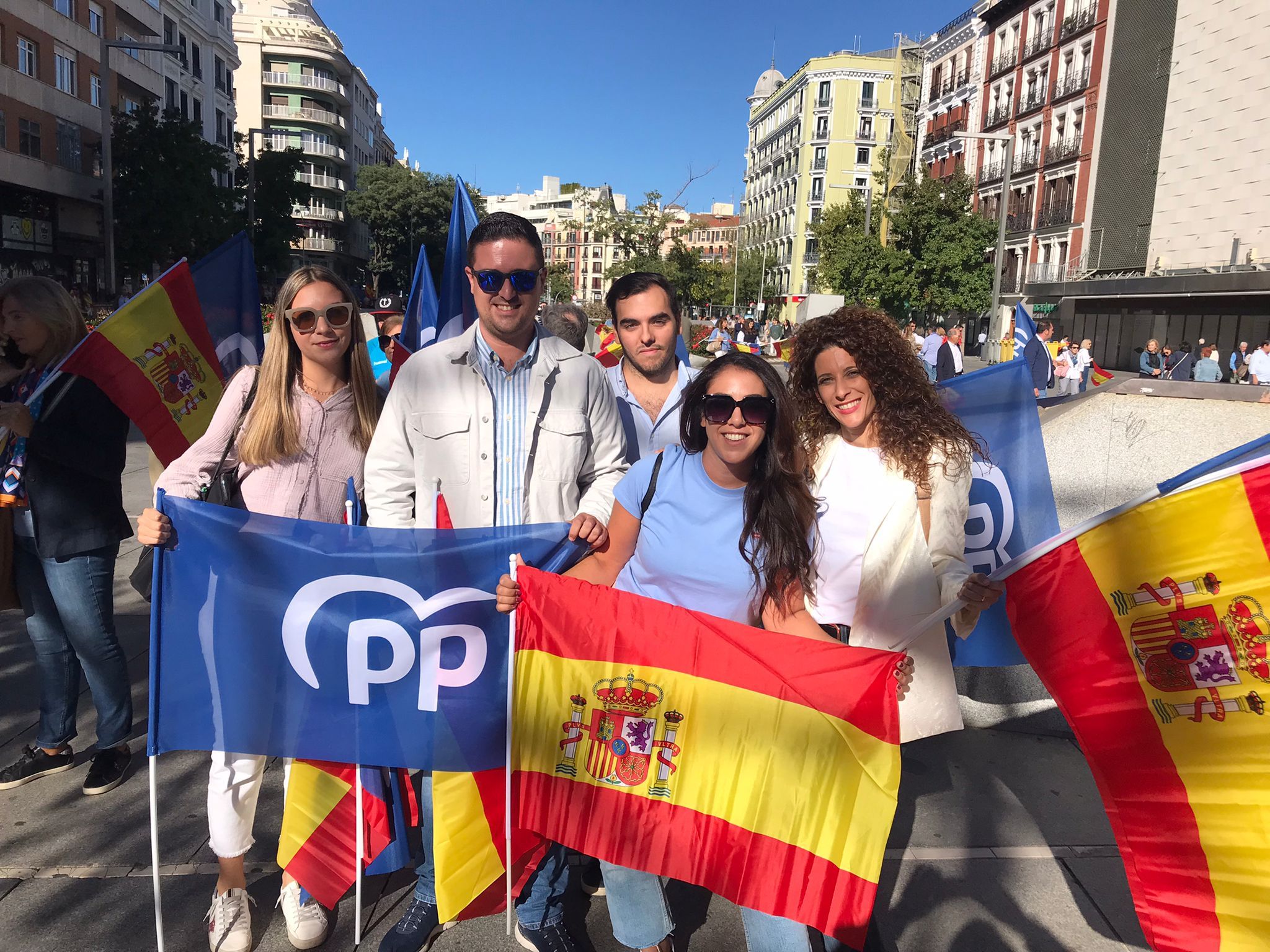 Cinco miembros de NNGG Écija en una calle de Madrid con banderas de España y del Partido Popular